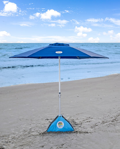 blue wind resistant beach umbrella on a windy beach day