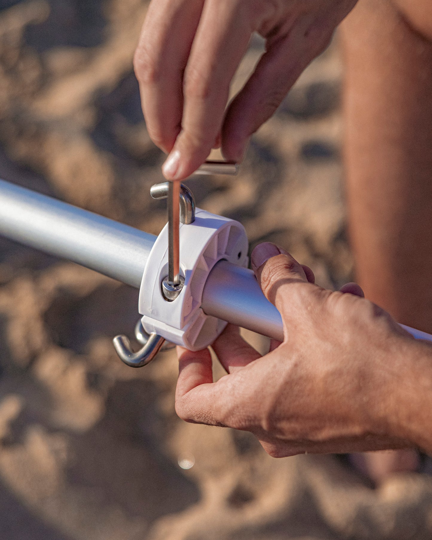 installing beach umbrella collar onto beach umbrella pole with allen wrench